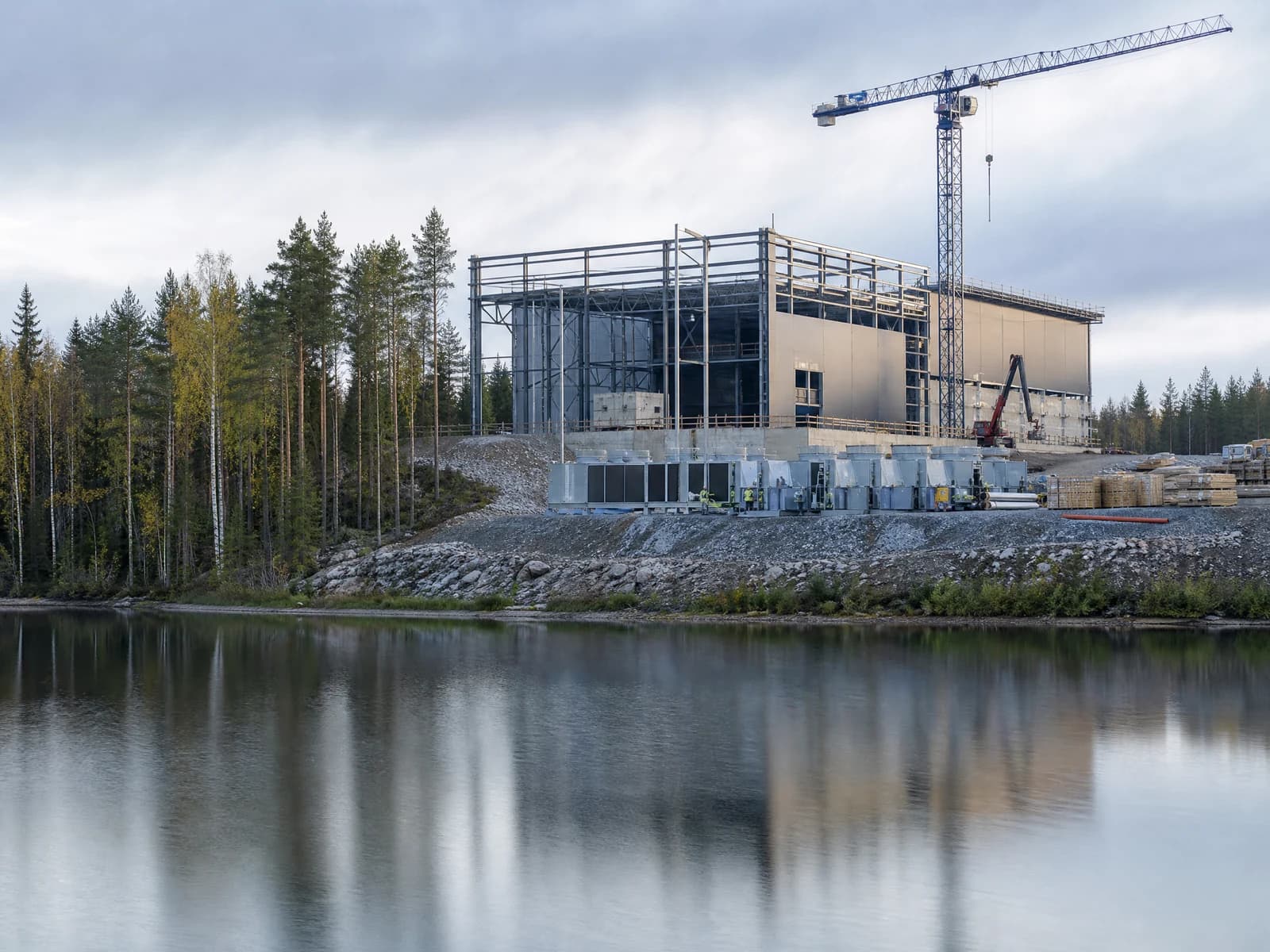 A data center construction site in Finland under northern light, crew in hi-vis on the steel frame